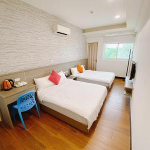 金宁乡欢乐满屋的酒店客房设有两张床和电视。