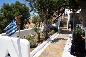 圣斯特凡诺斯Zisis Pension的花园中带希腊国旗的房子