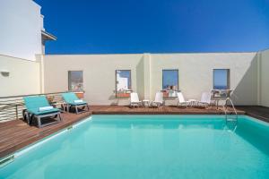圣克鲁斯-德特内里费圣克鲁斯现代公寓的一个带椅子的游泳池和一个带游泳池的甲板