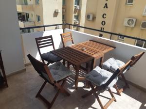 ScalaBeautiful apartment near beach in Larnaca的阳台上的木桌和椅子