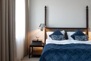 斯德哥尔摩Elite Palace Hotel & Spa的一间卧室配有一张带蓝色棉被和枕头的床