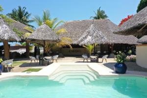 Ambondrona诺西贝酒店及水疗中心的度假村的游泳池,配有椅子和遮阳伞