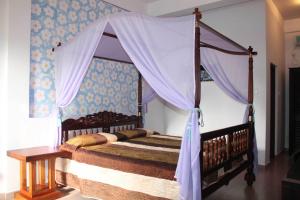 马拉维拉所罗门海滩酒店 的一间卧室配有一张天蓬床和一张桌子