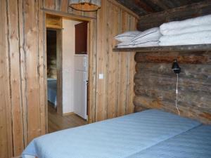 KarhujarviKarhujärven Kelopirtit的一间卧室设有一张床和木墙