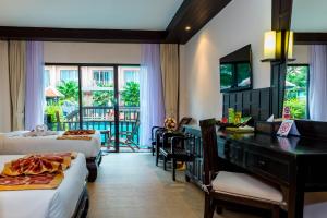 芭东海滩尼帕度假酒店 （政府卫生认证）的酒店客房设有两张床、一张书桌和一个阳台。