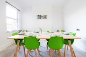 诺丁汉Jasmine Villa B - Ideal for QMC & Uni - Free parking的一间带木桌和绿色椅子的用餐室