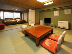 琴平町こんぴら温泉湯元八千代的客厅配有木桌和床。