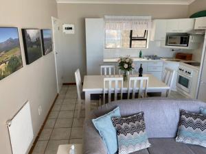 赫罗德斯湾Herolds Bay Accommodation - Hiers Ons Weer Upstairs的客厅以及带沙发和桌子的厨房。