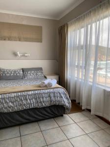 赫罗德斯湾Herolds Bay Accommodation - Hiers Ons Weer Upstairs的一间卧室设有一张床和一个大窗户