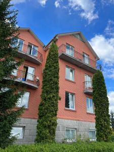 StarovoitoveГотель Ягодин的前面有两棵树的红砖建筑