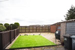 DouglasRigside House的一个带围栏和绿色草坪的小后院
