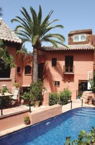 贝纳阿维斯阿曼哈维斯酒店的棕榈树和游泳池的房子