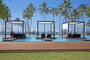 瓦伊卡尔素里亚度假酒店的度假村的游泳池,以棕榈树为背景