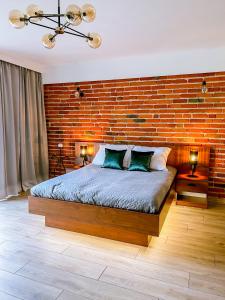 GłownoDomek pod Katalpami的一间卧室设有砖墙和一张床