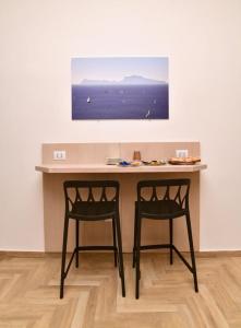 那不勒斯Il Picchio di Chiaia的墙上有一张桌子和两把椅子