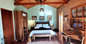 圣本图-杜萨普卡伊Hospedaria Aikó的一间卧室设有一张床和木墙