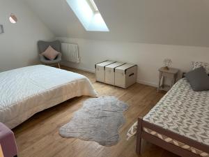 奥尔西瓦勒La grange的卧室配有两张床,地板上铺有地毯。