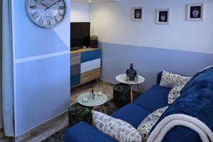 沙斯讷伊迪普瓦图La Bulle Bleue futuroscope的客厅配有蓝色的沙发和时钟