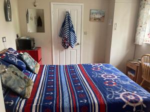 WarsashCove Cott的一间卧室配有一张带彩色毯子的床