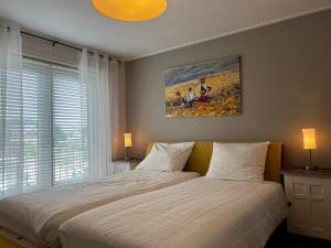 德科赫Texelheerlijk 4的卧室配有一张床,墙上挂有绘画作品