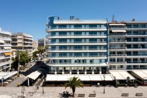 哈尔基斯帕里瑞亚酒店的一座蓝色的大建筑,前面有一棵棕榈树