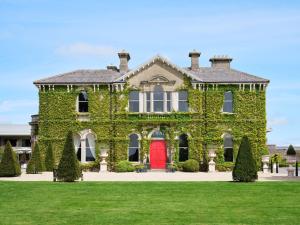 基尔肯尼Lyrath Estate的红门遮盖在常春藤上的房子