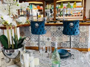 斯旺西Entire Pub Sleeps up to 26 People Swansea - Your Own Pub Experience的一张桌子,上面有蓝色的椅子和眼镜