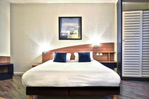 庞坦巴黎艺术酒店 的一间卧室配有一张带蓝色枕头的大床