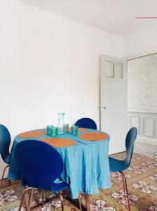 亚眠Irziana - Au jardin d'Henriville的一张带蓝色椅子和蓝色桌布的桌子