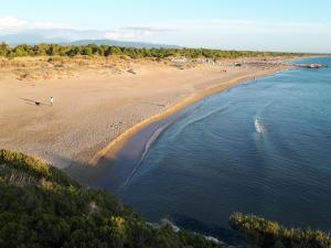 卡洛吉亚Villa Dunes 350m from the sandy beach的海滩上的人的空中景色