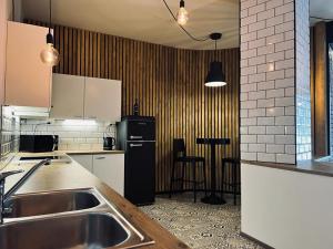 劳马瓦哈劳玛酒店的厨房配有水槽和黑冰箱。