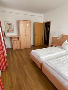 Buggingenzum Schwanen Garni的一间卧室设有两张床,铺有木地板