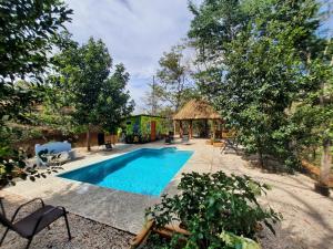 萨玛拉Eco-Turismo Guayacanes的一座带房子的庭院内的游泳池