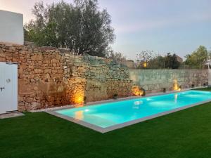 塞萨利内斯Can Roig的石头墙前的游泳池