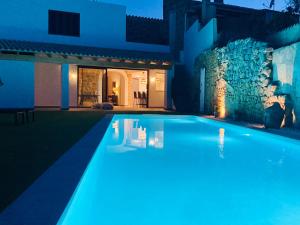 塞萨利内斯Can Roig的夜间在房子前面的游泳池