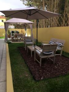 拉布鲁吉Casa de Praia Guest House的院子里的一组椅子和一把伞