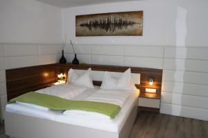 克拉根福Hotel Weidenhof的卧室配有白色的床和木制床头板