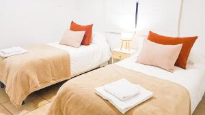门多萨Casa Huesped Mendoza Modernismo y confort en este hermoso apartamento !!的两张睡床彼此相邻,位于一个房间里