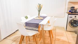 门多萨Casa Huesped Mendoza Modernismo y confort en este hermoso apartamento !!的餐桌、白色椅子和蓝色桌布