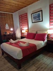 锡拉奥雪酒店的一间卧室配有一张带红色和白色枕头的大床