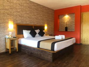 埃莫西约埃莫西约殖民风格酒店的一间卧室设有一张带红色墙壁的大床