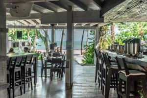 伊卡莱DePraiaBrasil的一间带桌椅的海景餐厅