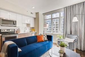 丹佛Sentral Union Station的一间带蓝色沙发的客厅和一间厨房