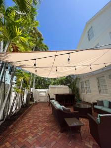 基韦斯特The Porch on Frances Inn - Adults Exclusive的庭院配有太阳伞、椅子和桌子