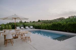 圣尼科拉阿尔切拉Dimora Manfredo Eco B&B Luxury的一个带桌子和遮阳伞的庭院和一个游泳池