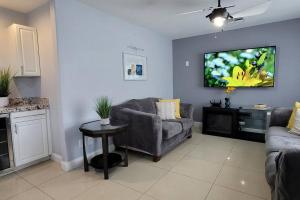 拉斯维加斯K - Fully remodeled and professionally decorated的客厅配有沙发和墙上的电视