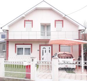 尼什Pansion Eden的粉红色的房子,有白色的栅栏和汽车