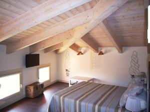 切塞纳蒂科La Finestra sul Porto的一间带一张床的卧室,位于带木制天花板的房间内