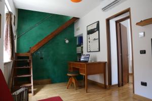 卡塞塔Vicolo degli Osci的客房设有书桌和绿色的墙壁。