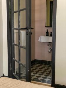 海斯勒霍尔姆Rallarhustruns的浴室设有玻璃门和水槽